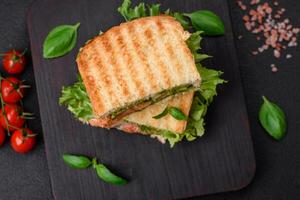 köstlich knusprig Sandwich mit Toast, Lachs, Avocado, Tomaten, Salz, Gewürze und Kräuter foto