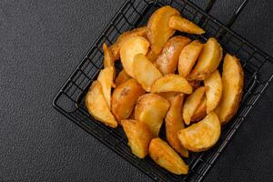 köstlich knusprig gebraten Kartoffel Keile mit Salz, Gewürze und Kräuter foto