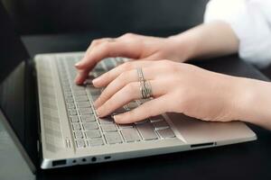 Geschäft Frau Arbeitsplatz. weiblich Hände auf Laptop Klaviatur. Nahansicht. weiblich Hände Tippen auf Computer Tastatur zum online Lernen foto