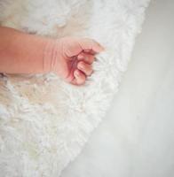 Neugeborenes Baby Hand auf weißem Bett. foto