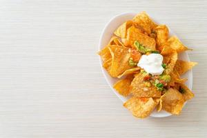 mexikanische Nachos-Tortilla-Chips mit Jalapeno, Guacamole, Tomatensalsa und Dip foto