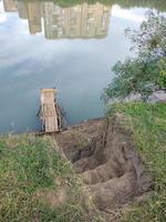 Schritte zur Kiefernbrücke am Fluss und das Spiegelbild der Häuser foto