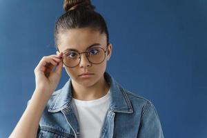 Ernsthaftes Teenager-Mädchen passt Brille an Kamera an
