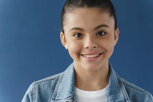 positives Teenager-Mädchen, das schön lächelt und in die Kamera schaut foto