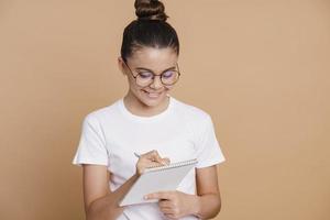 lächelndes Teenager-Mädchen mit hochgezogenen Haaren und Brille foto