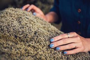 Frau, die das Steinmoos in der Natur berührt und Emotionsenergie austauscht foto