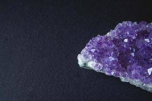 lila Amethystkristall auf schwarzem Hintergrund