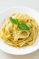 Pesto-Fettuccine-Nudeln mit Parmesan-Käse obenauf - italienische Küche foto