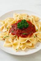 Farfalle-Nudeln in Tomatensauce mit Petersilie - italienische Küche foto