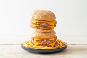 Schweinefleisch-Hamburger oder Schweinefleisch-Burger mit Käse und Pommes frites foto