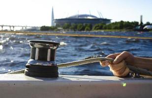 gut aussehender Mann, der an einem Segelboot arbeitet. Wassersport. foto