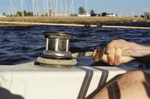 gut aussehender Mann, der an einem Segelboot arbeitet. Wassersport. foto