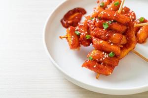 frittierter koreanischer Reiskuchen - Tteokbokki-Spieß mit scharfer Sauce - koreanischer Essensstil foto