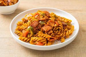 gebratene Fusilli-Nudeln mit Schinken-Tomaten-Sauce foto