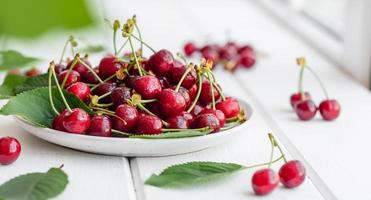 frische köstliche rote leuchtende Kirschbeeren im Sommergarten gerissen foto