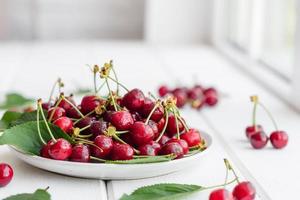 frische köstliche rote leuchtende Kirschbeeren im Sommergarten gerissen foto