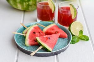 frische leckere Wassermelone in Scheiben geschnitten mit Minze und Wassermelonensaft foto