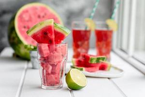 frische leckere Wassermelone in Scheiben geschnitten mit Minze und Wassermelonensaft foto