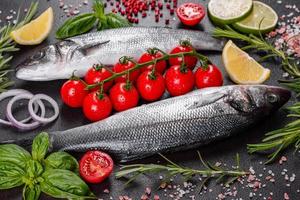 frischer Fisch, Wolfsbarsch und Zutaten zum Kochen. roher Fisch Wolfsbarsch foto