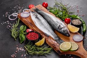 frischer Fisch, Wolfsbarsch und Zutaten zum Kochen. roher Fisch Wolfsbarsch foto