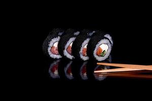 frische köstliche schöne Sushi-Rollen auf dunklem Hintergrund foto