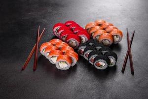 frische köstliche schöne Sushi-Rollen auf dunklem Hintergrund foto