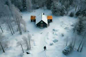 Antenne Schuss von einsam Zahl in der Nähe von Kabinen im schneebedeckt Schweden ai generiert foto