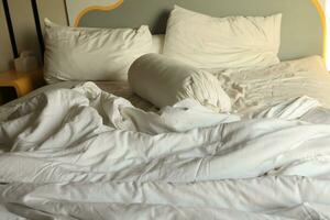 unordentlich Hotel Bett. Weiß Kopfkissen. Weiß rollen. Weiß Decke. foto