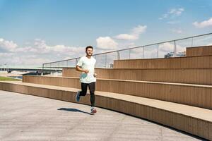 ein Mann Ausbildung Fitness im ein komfortabel T-Shirt. ein Trainer mit Brille tut ein Laufen Übung jeder Tag, ein gesund Lebensstil. ein sportlich Person Verwendet ein Fitness Uhr und ein Laufen App. foto