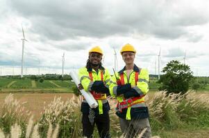 Porträt von Clever Ingenieur mit schützend Helm beim elektrisch Turbinen Feld foto