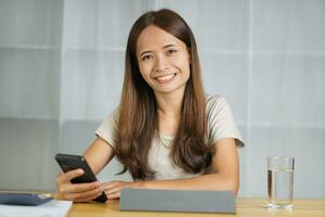 asiatisch Frau Arbeiten beim Zuhause Kontakt mit Kunden über Telefon foto
