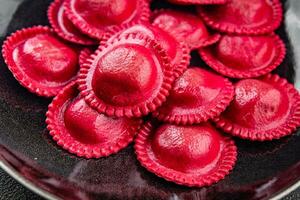 Zuckerrüben Ravioli rot Farbe Fleisch Füllung geräuchert Schinken Kochen Vorspeise Mahlzeit Essen Snack auf das Tabelle foto