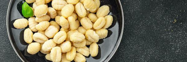 Gnocchi roh Essen Kartoffel Snack Mahlzeit Essen auf das Tabelle Kopieren Raum Essen Hintergrund rustikal oben Aussicht foto