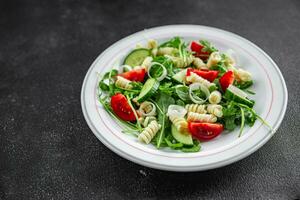 Pasta Salat Fusilli Pasta, Gurke, Tomate, Grün Kopfsalat, Zwiebel köstlich gesund Essen Kochen Vorspeise Mahlzeit Essen Snack auf das Tabelle Kopieren Raum Essen Hintergrund foto