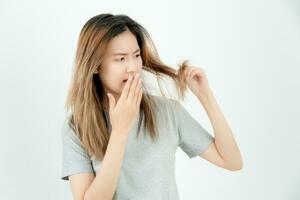 asiatisch Frau sehr traurig und verärgert suchen beim beschädigt Haar, Haar Verlust, Haar Verdünnung Problem, Vitamin Mangel, Kahlheit, nach der Geburt, Biotin, Zink, Menstruation- oder endokrine Störungen, hormonell Ungleichgewicht foto