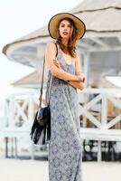 ziemlich schlank Frau im modisch Sommer- Outfit posieren in der Nähe von Luxus Resort in der Nähe von das Strand foto