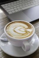 Morgenkaffee Latte auf Holzschreibtisch Arbeit aus dem Homeoffice foto
