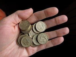 Hand hält Pfundmünzen foto