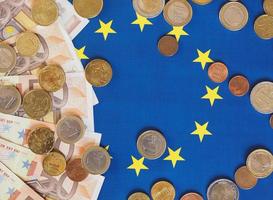Euro-Banknoten und -Münzen, Europäische Union, über Flagge