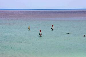 mehrere Menschen Windsurfen im das Ozean foto