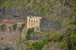 ein alt Gebäude auf das Seite von ein Cliff foto