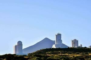 das Observatorium beim das oben von ein Hügel mit ein Berg im das Hintergrund foto