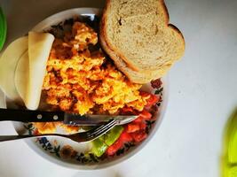 Foto von ein köstlich Frühstück Teller mit durcheinander Eier, Toast, und Gemüse