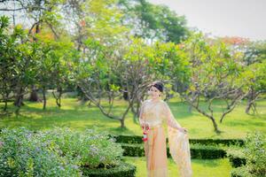 traditionell thailändisch Kostüm schön Frau gehen im Garten foto