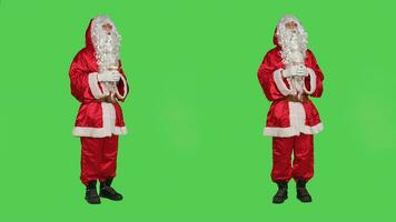 Santa claus Getränke Tasse von heiß Schokolade im rot festlich Winter Kostüm mit hätten und Gläser, genießen Kaffee Getränk auf grüner Bildschirm Hintergrund. Vater Weihnachten mit saisonal Erfrischung. foto