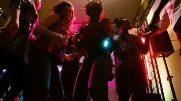 pov von freunde Tanzen beim Disko Party, genießen Sozial Versammlung mit modern Clubbing Musik- auf tanzen Boden. Gruppe von Menschen haben Spaß zusammen beim tanzen Veranstaltung im Diskothek. Handheld Schuss. foto