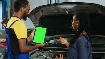 afrikanisch amerikanisch Soldat mit Grün Bildschirm Laptop zu Show Frau beschädigt Teile gefunden im ihr Wagen. Experte mit isoliert Gerät zu Hilfe Klient visualisieren Reparaturen Das brauchen zu Sein erledigt zu Fahrzeug foto