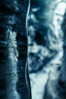 Wasser tropft von Eis Felsen im Höhle, Klima Veränderung Konzept. fest eisig Blöcke schmelzen Innerhalb vatnajokull Eisberg Gletscherspalte, isländisch Natur bewundert durch Gletscher wandern. foto