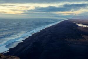 Nord Küste mit schwarz Sand Strand, hervorragend Aussicht von Wildnis mit Wellen abstürzen. gefroren Paradies im Island mit wunderbar Strände mit Felsen und Gewässer, Straßenrand. foto