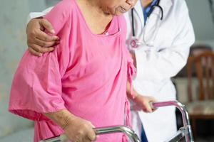 asiatische ältere Frau Patientenspaziergang mit Gehhilfe foto
